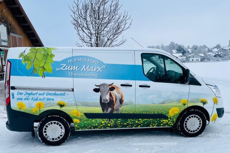 Lieferwagen Hofmolkerei Almwiese mit bunten Blumen